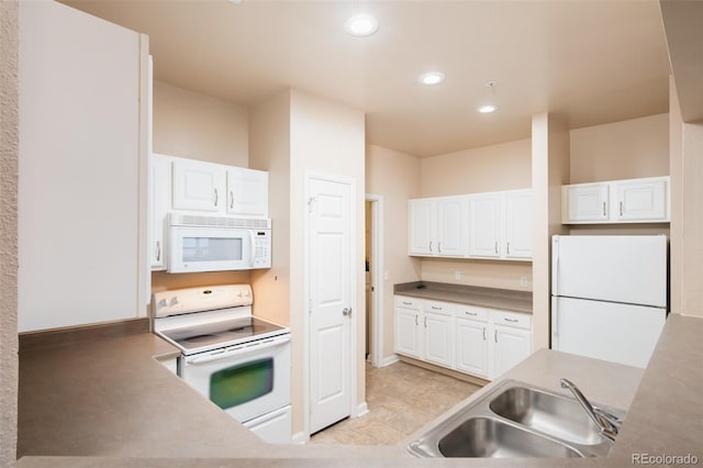 kitchen featuring white cabinetry, white appliances, and a sink