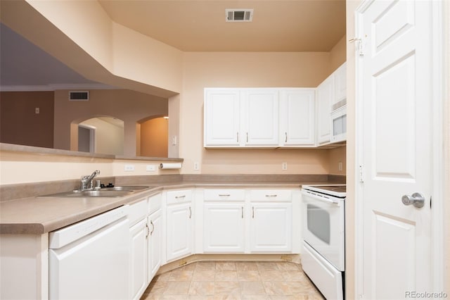 kitchen with a sink, visible vents, white appliances, and white cabinets