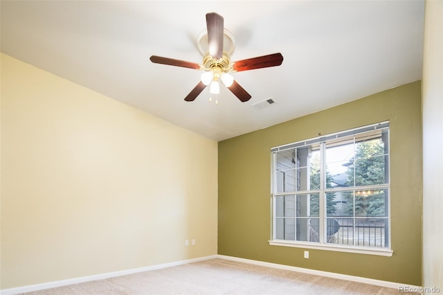 unfurnished room featuring a ceiling fan, baseboards, visible vents, and light carpet