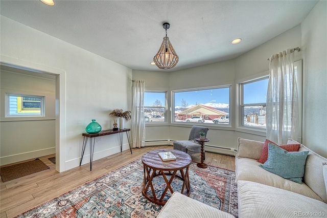 living room with recessed lighting, wood finished floors, baseboards, and baseboard heating