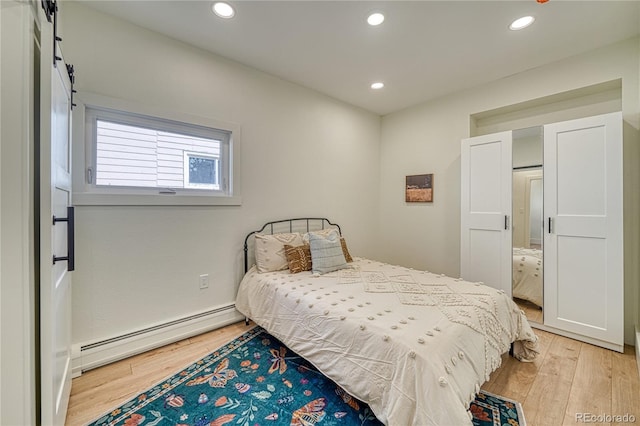 bedroom with a baseboard heating unit, recessed lighting, and light wood-style floors