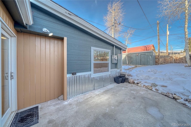 view of patio / terrace featuring an outbuilding, a shed, visible vents, and fence