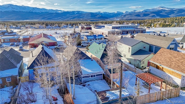 snowy aerial view featuring a mountain view and a residential view