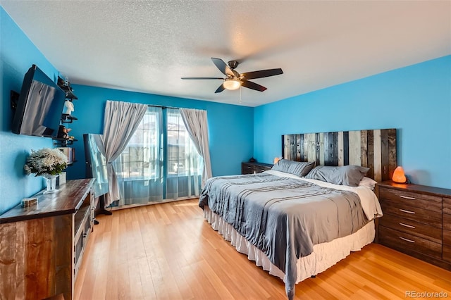 bedroom featuring a textured ceiling, a ceiling fan, and wood finished floors