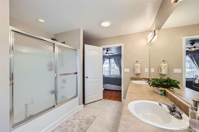 ensuite bathroom with tile patterned flooring, a sink, ensuite bath, and bath / shower combo with glass door