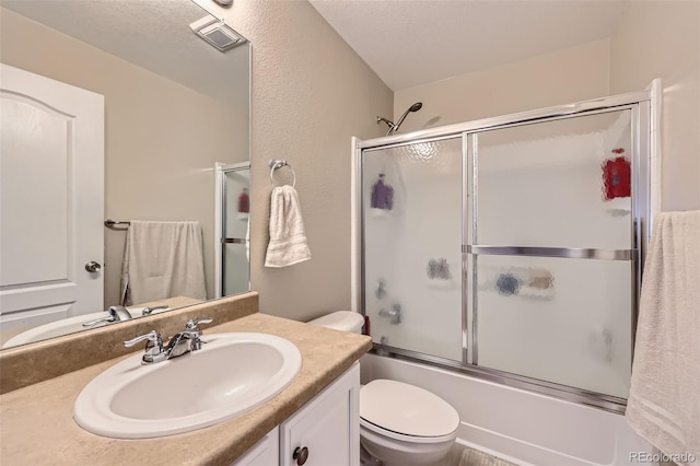 full bath featuring visible vents, toilet, shower / bath combination with glass door, a textured ceiling, and vanity