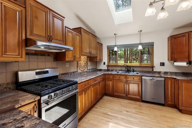 1343 Terri Ln, Woodland Park, CO 80863 - kitchen with appliances with stainless steel finishes, brown cabinets, a skylight, under cabinet range hood, and light wood-style floors