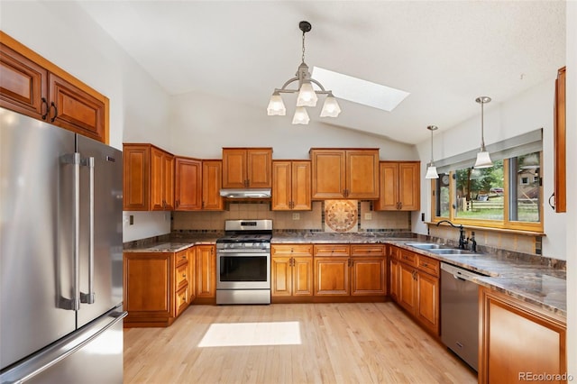 1343 Terri Ln, Woodland Park, CO 80863 - kitchen featuring stainless steel appliances, a skylight, brown cabinets, vaulted ceiling, and light wood-style flooring