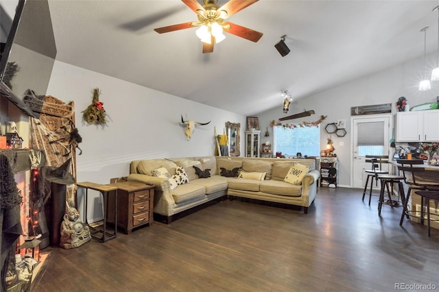 living room with a ceiling fan, vaulted ceiling, and dark wood finished floors