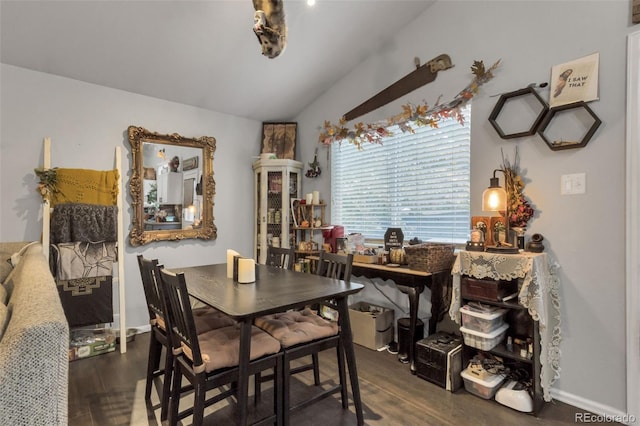 dining room featuring vaulted ceiling and dark hardwood / wood-style flooring