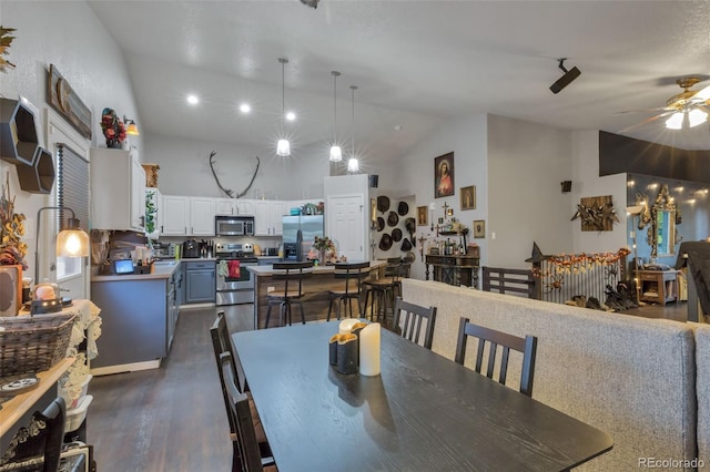 dining area featuring dark wood-style flooring, ceiling fan, and high vaulted ceiling