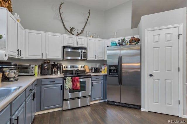 kitchen featuring white cabinets, gray cabinets, stainless steel appliances, and dark hardwood / wood-style flooring