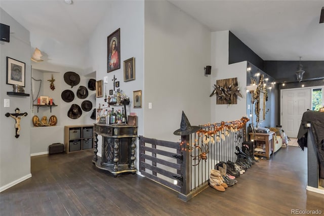 stairway with lofted ceiling, baseboards, and wood finished floors