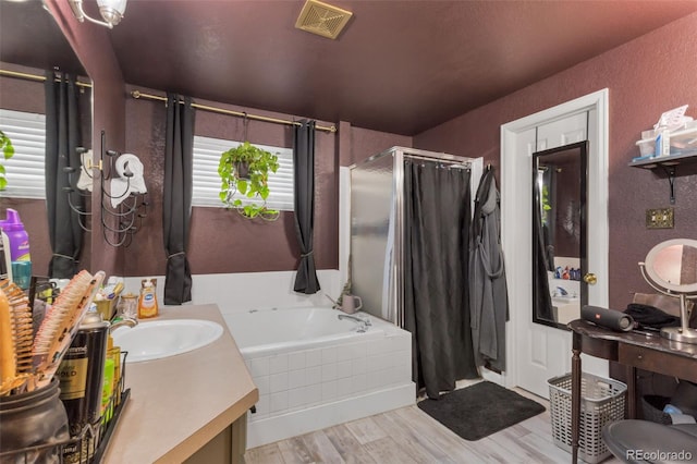 bathroom featuring plus walk in shower, hardwood / wood-style floors, and vanity