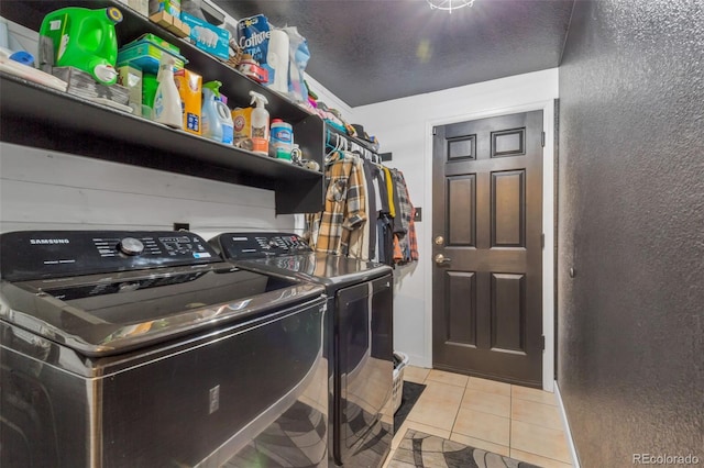 clothes washing area featuring washer and dryer and light tile patterned floors