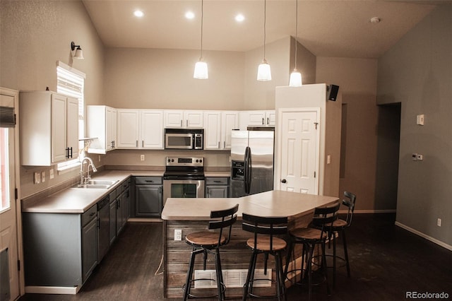 11384 Oakland Dr, Commerce City, CO 80640 - kitchen with stainless steel appliances, gray cabinets, a towering ceiling, a sink, and a kitchen island