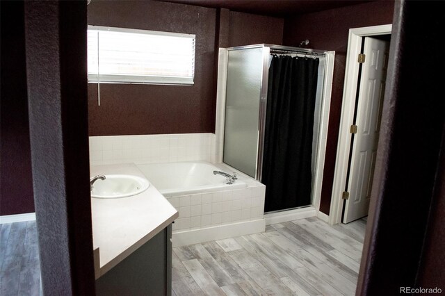 11384 Oakland Dr, Commerce City, CO 80640 - bathroom with a shower stall, a garden tub, wood finished floors, vanity, and a textured wall