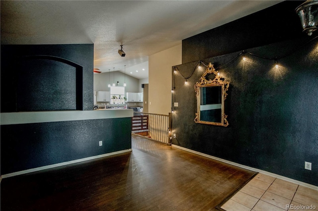 11384 Oakland Dr, Commerce City, CO 80640 - unfurnished dining area featuring lofted ceiling, tile patterned flooring, and baseboards