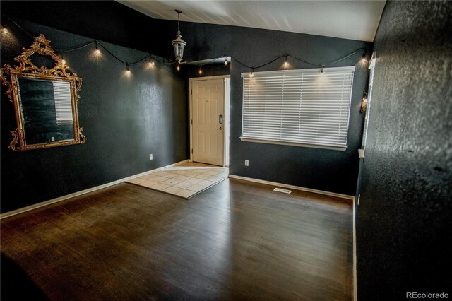 11384 Oakland Dr, Commerce City, CO 80640 - empty room with vaulted ceiling, wood finished floors, and baseboards