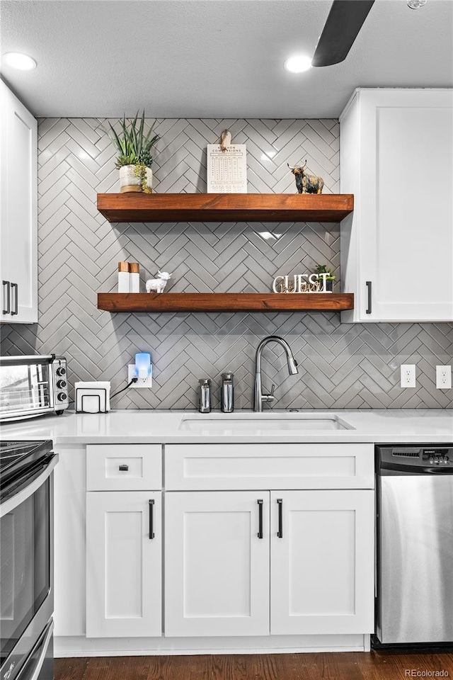 kitchen featuring decorative backsplash, sink, white cabinetry, and appliances with stainless steel finishes