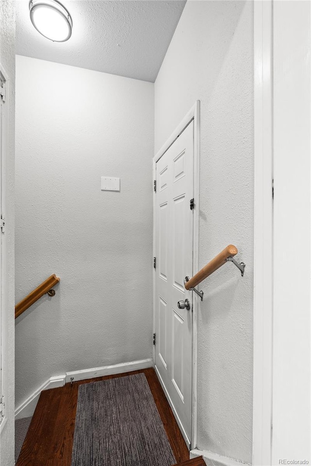 staircase featuring hardwood / wood-style flooring and a textured ceiling