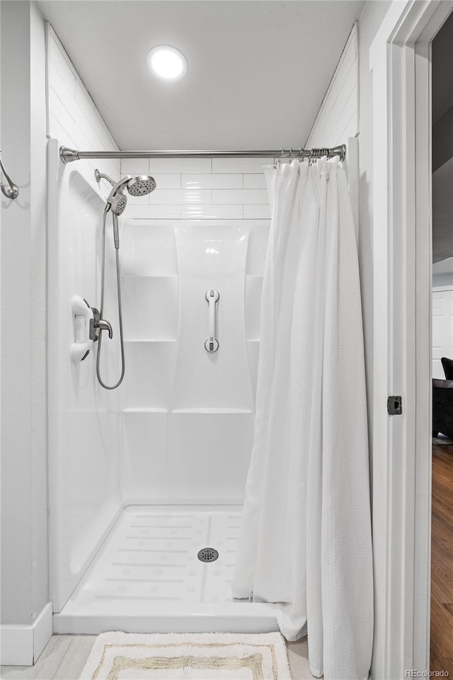 bathroom featuring curtained shower and hardwood / wood-style floors