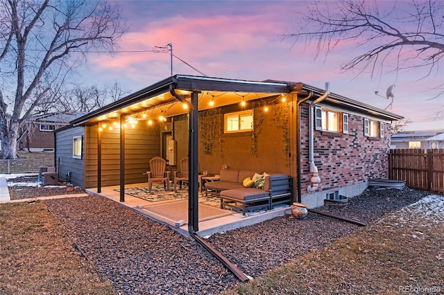 back house at dusk with a patio area