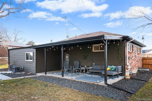 rear view of property featuring a patio area and outdoor lounge area