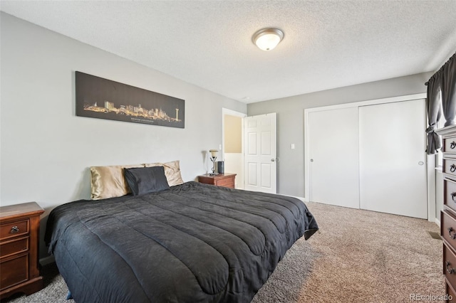 bedroom featuring a closet, a textured ceiling, and carpet floors