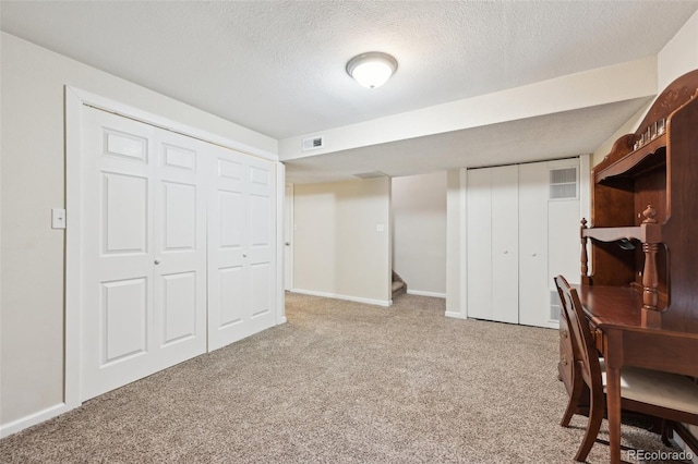 interior space with carpet flooring, visible vents, baseboards, and a textured ceiling