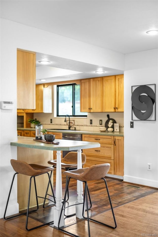 7603 W Coal Mine Pl, Littleton, CO 80128 - kitchen with a kitchen breakfast bar, a peninsula, stainless steel dishwasher, recessed lighting, and dark wood-style flooring