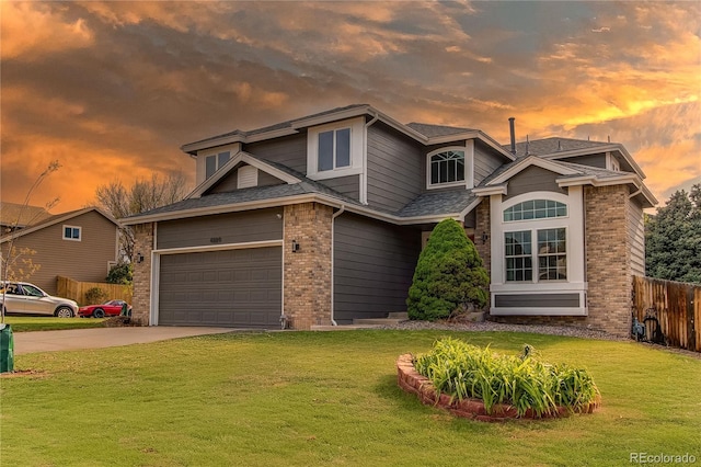 traditional home with fence, concrete driveway, a yard, roof with shingles, and brick siding