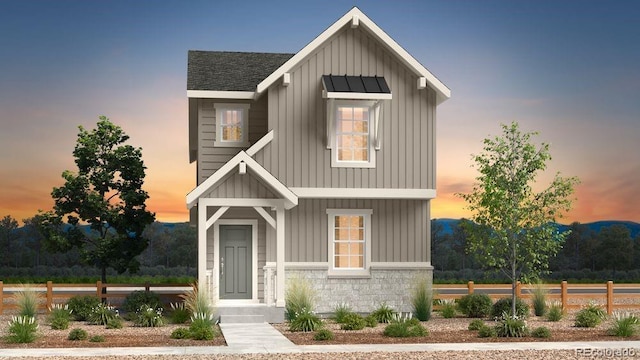 modern farmhouse with board and batten siding, stone siding, and roof with shingles