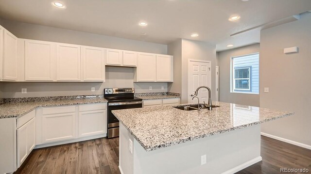 kitchen with dark wood finished floors, stainless steel electric range oven, white cabinetry, a sink, and recessed lighting