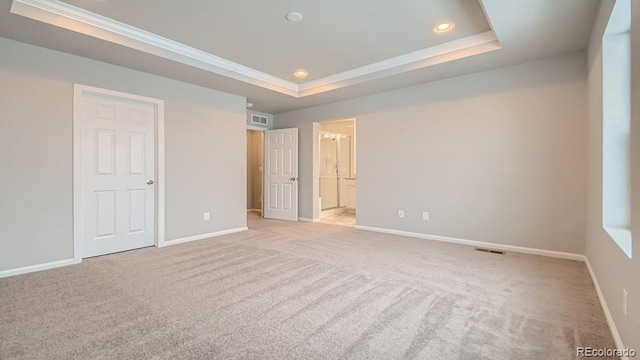 unfurnished bedroom featuring recessed lighting, carpet flooring, visible vents, baseboards, and a tray ceiling