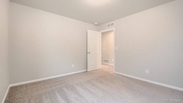 carpeted empty room with visible vents and baseboards