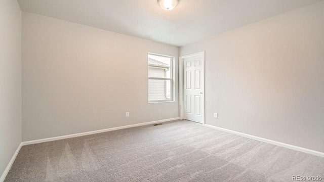 empty room with carpet and baseboards