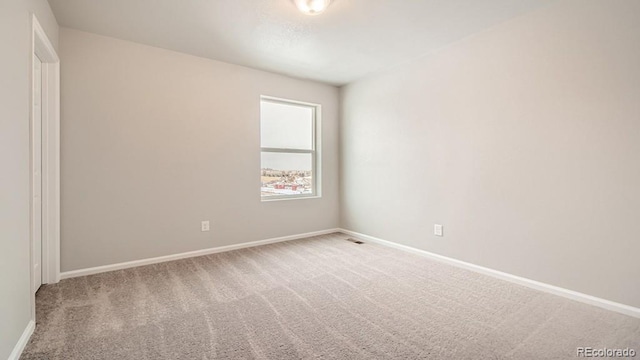 unfurnished room with carpet flooring and baseboards