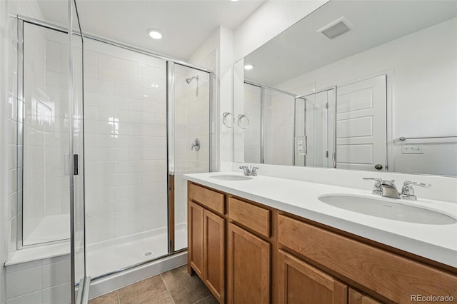 2116 Chambers Rd, Brighton, CO 80601 - bathroom featuring double vanity, visible vents, a stall shower, and a sink