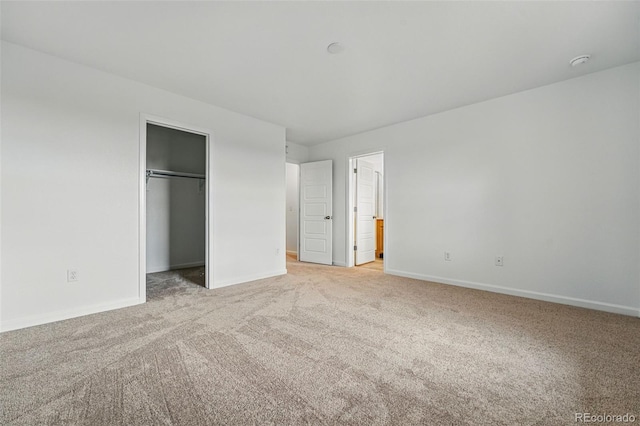 2116 Chambers Rd, Brighton, CO 80601 - unfurnished bedroom featuring a closet, baseboards, connected bathroom, a spacious closet, and carpet floors