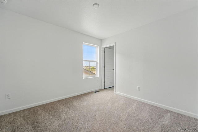 2116 Chambers Rd, Brighton, CO 80601 - spare room featuring baseboards, visible vents, and light colored carpet