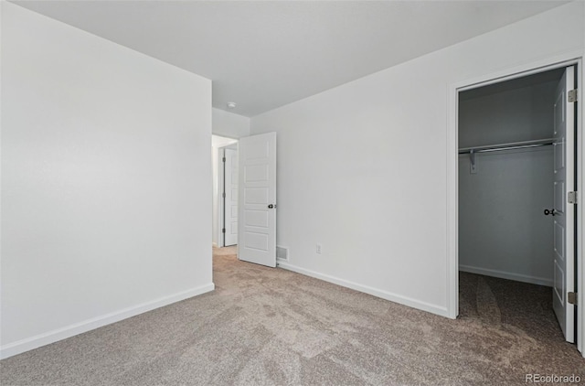 2116 Chambers Rd, Brighton, CO 80601 - unfurnished bedroom featuring carpet, a closet, baseboards, and a walk in closet
