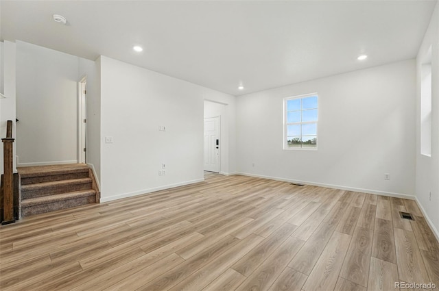 2116 Chambers Rd, Brighton, CO 80601 - unfurnished living room featuring stairs, visible vents, baseboards, light wood-style floors, and recessed lighting