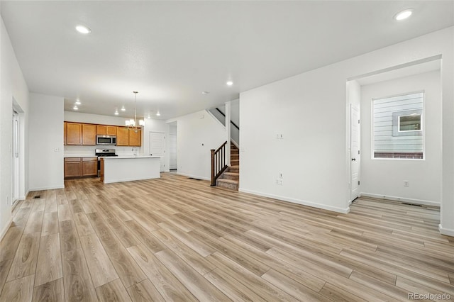 2116 Chambers Rd, Brighton, CO 80601 - unfurnished living room with stairway, light wood finished floors, and recessed lighting