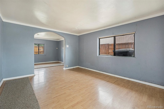2280 S Decatur St, Denver, CO 80219 - empty room with arched walkways, baseboards, wood finished floors, and crown molding