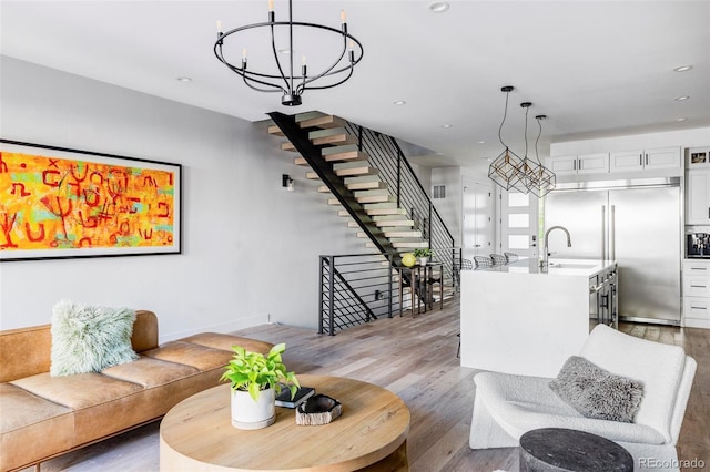 living room featuring sink, a chandelier, and hardwood / wood-style floors