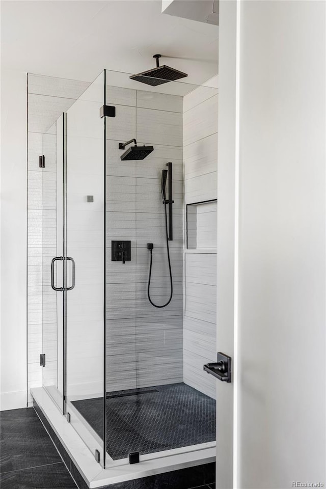 bathroom with tile patterned flooring and a shower with shower door