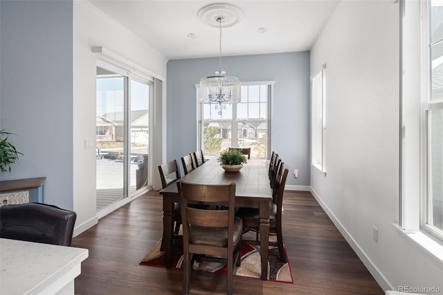 dining space with a notable chandelier, baseboards, and dark wood-style flooring