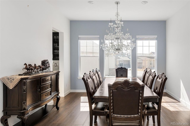 dining area featuring a notable chandelier, wood finished floors, and baseboards