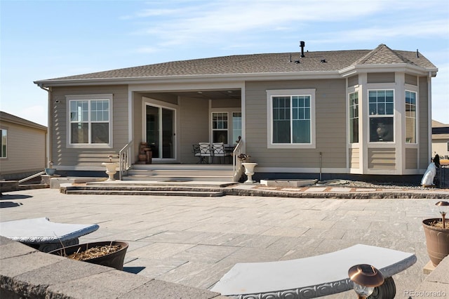 back of house featuring a patio and a shingled roof